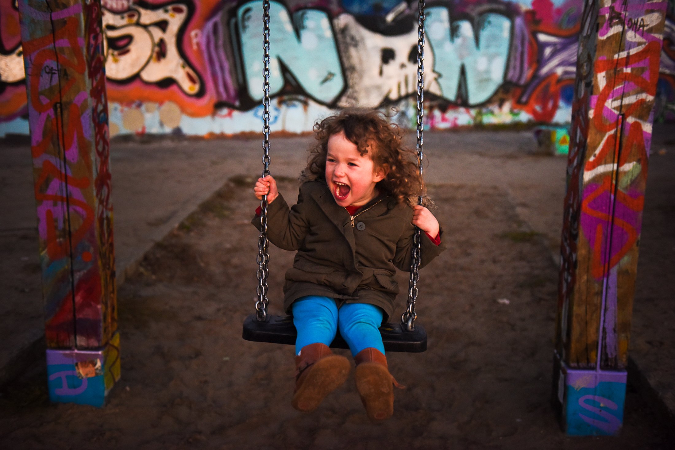 A child laughing on a swing