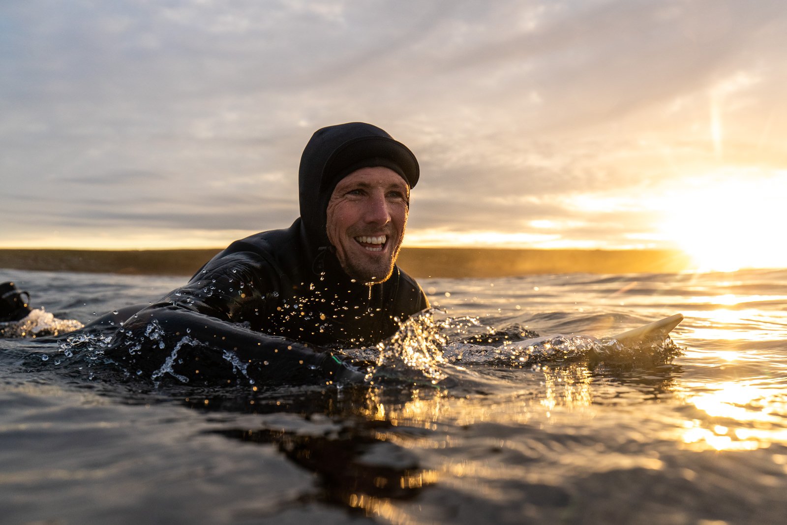 A surfer smiling in evening light