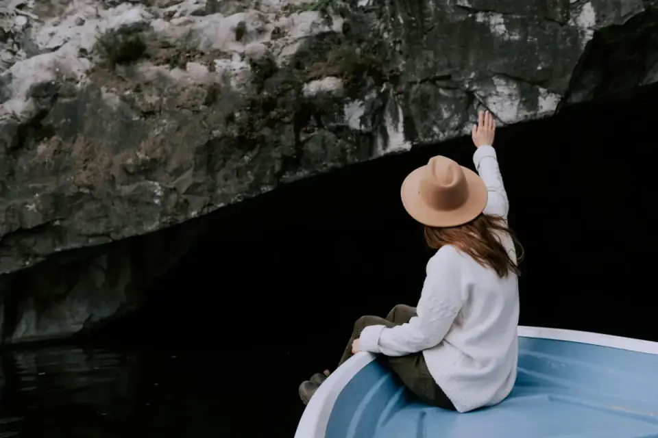Person sitting beside a rocky lake