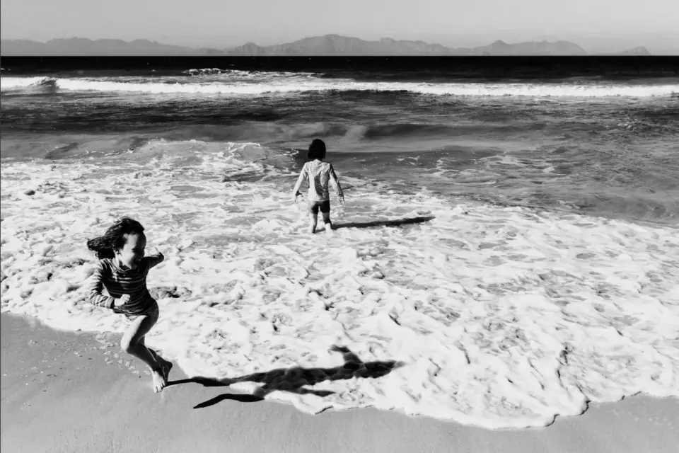Children running beside the sea